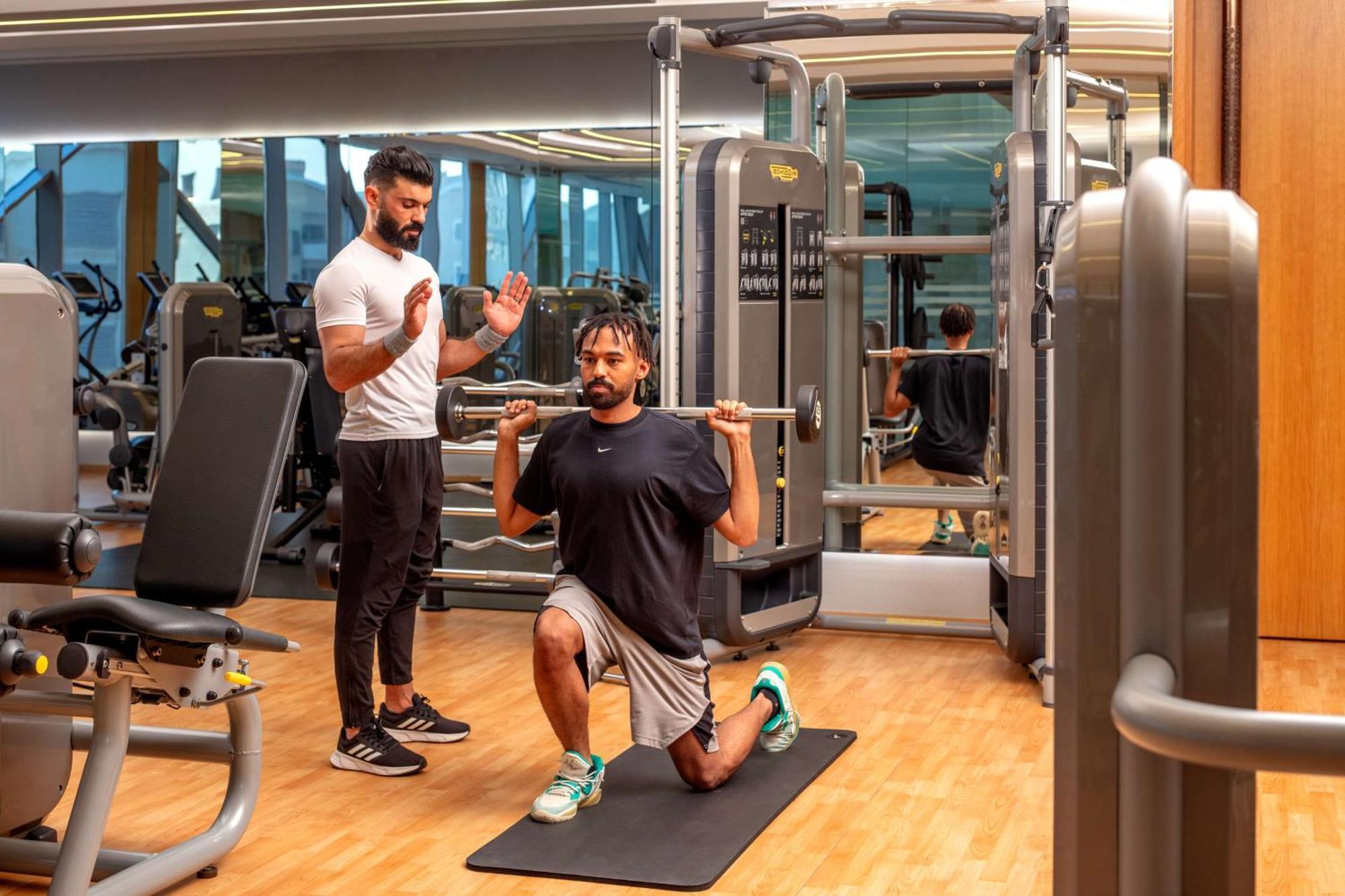 Hyatt Regency Riyadh Olaya Exteriér fotografie Personal trainer coaching a man on a Bulgarian split squat